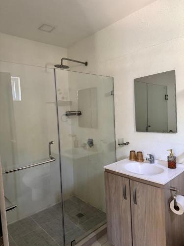 a bathroom with a glass shower and a sink at Entre Palmas Venao in Playa Venao