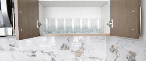 a bathroom with glasses on a shelf with white marble at Spacious 4BR Home with EV Charger in Cambridge