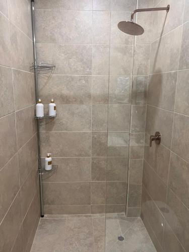 a bathroom with a shower with a glass door at Puerto Beach House in Puerto Colombia