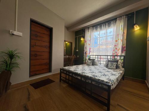 a bedroom with a bed in front of a window at GD Homestay in Shillong