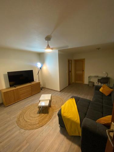 a living room with a couch and a flat screen tv at La loge in Marigot
