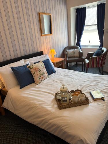 a bed with a tray of food on it at Kinkell House in Inverness