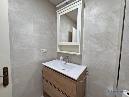 a bathroom with a sink and a mirror at Apartamento Barro Playa in Barro de Llanes