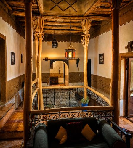 a living room with a couch in the middle of a building at Riad Des Vieilles Charrues in Boumalne Dades