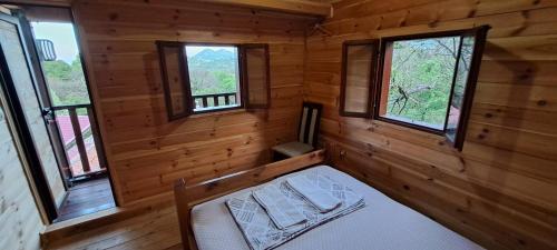 a room with a bed in a cabin with windows at TreeHouse in Bar