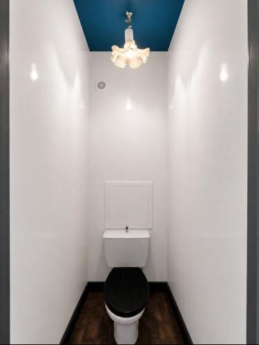 a white bathroom with a toilet and a chandelier at Appartement en plein centre, Vue port et clim in Cap d'Agde