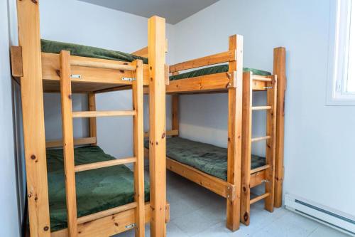 two wooden bunk beds in a room at Camp Val Notre-Dame in Herouxville