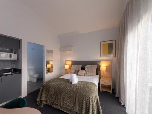 a hotel room with a bed and a toilet at Corrigans Cove Resort Batemans Bay in Batemans Bay
