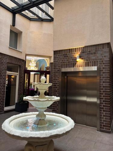 a fountain in the middle of a lobby with a building at Hotel Golden Pearl Magdeburg im Stadtzentrum in Magdeburg