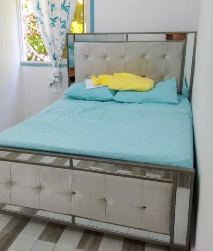 a bed with a metal frame and a yellow pillow at Two-Bedroom Apartment with Ocean View in La Ciénaga