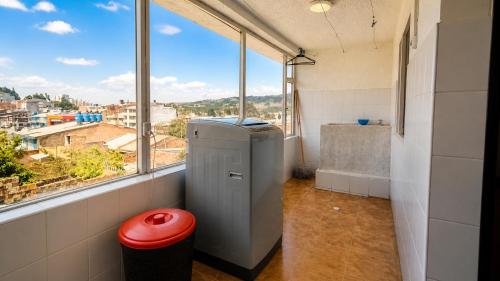 a bathroom with a large window and a small refrigerator at Apartamentos CasaMJ Tunja Confort y Parqueadero in Tunja