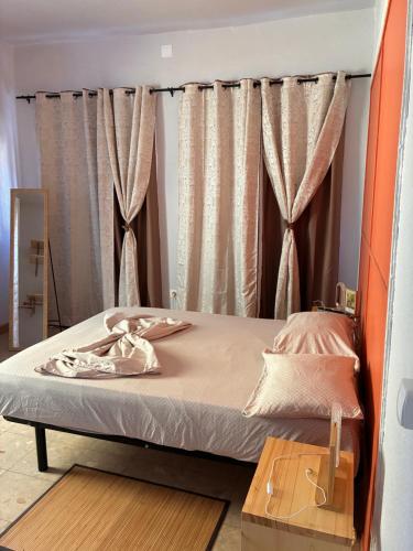 a bed in a room with curtains at Sol, Terra e Mar- No coração do Plateau in Praia