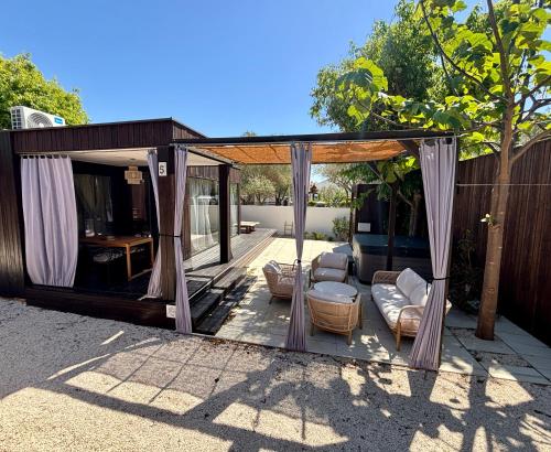 a pavilion with curtains and couches on a patio at Stylish beach house in Privlaka in Privlaka