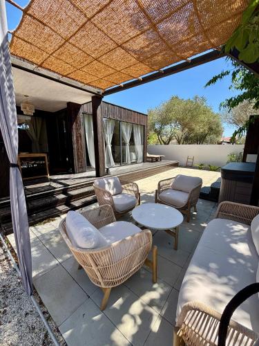a patio with wicker chairs and tables and a table at Stylish beach house in Privlaka in Privlaka