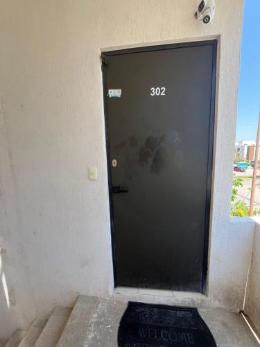 a black door with the number on it at Casa Claliz in Los Algodones