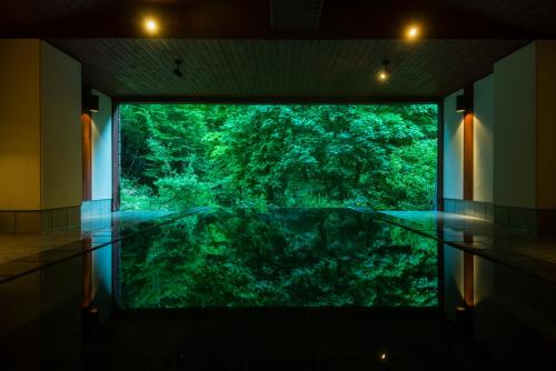 a room with a large window looking into a fish tank at Myojinkan in Matsumoto