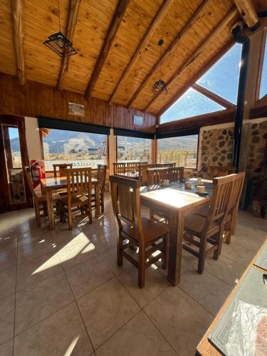 a dining room with tables and chairs and windows at Gr Turismo in Los Molles