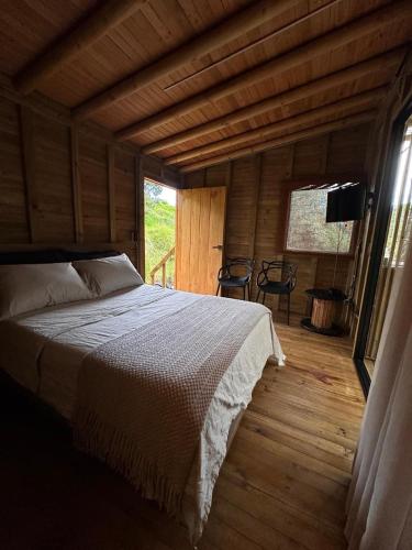 a bedroom with a bed in a wooden house at Casa dharma in Medellín