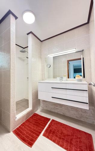 a bathroom with a shower and a sink and a mirror at Your Tahiti Escape in Faaa