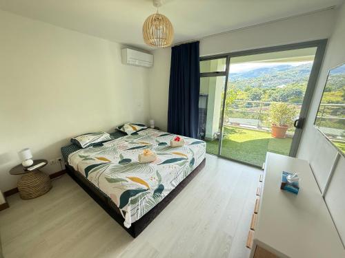 a bedroom with a bed and a large window at Your Tahiti Escape in Faaa