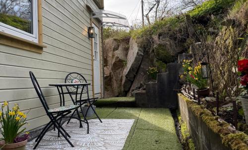 a patio with a table and chairs next to a house at Leilighet midt i Sokndal sentrum in Sokndal