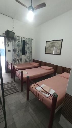 a room with four beds and a ceiling fan at Pousada Regis Bocaina SJB in São José do Barreiro