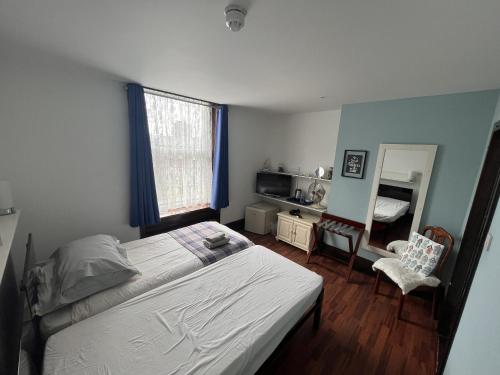 a bedroom with a bed and a desk and a mirror at Breeze Guest House in Bootle