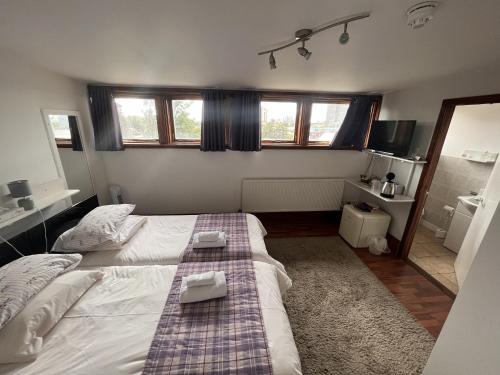 a bedroom with a bed with two towels on it at Breeze Guest House in Bootle