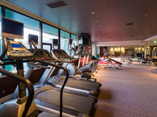 a gym with a bunch of treadmills and machines at Kobe Bay Sheraton Hotel & Towers in Kobe