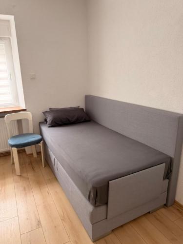 a bed in a room with a blue chair at Appartement Heidstock in Völklingen