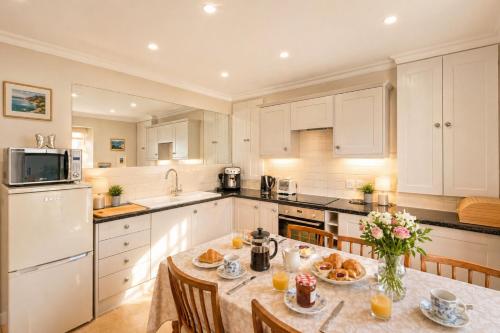 a kitchen with a table with food on it at The Old Post Office - Parking Available - 75 meters Estuary in Salcombe