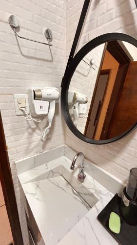 a bathroom with a sink and a mirror at Casa Aconchegante Uberlândia in Uberlândia
