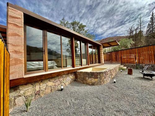 a house with a stone wall and windows at Tierra Viva in Purmamarca