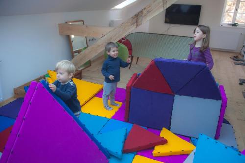 two children playing in a play room with colored blocks at Niedermairhof in Brunico