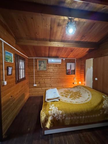 a bedroom with a large bed in a wooden room at Florea Cottage in Ulcinj