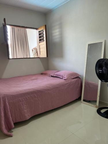 a bedroom with a bed and a mirror at Maria Luiza da silva in Japaratinga