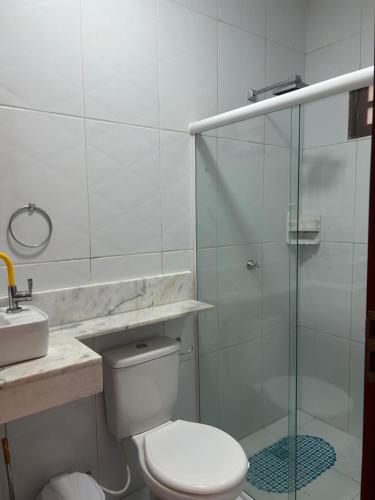 a bathroom with a toilet and a glass shower at Maria Luiza da silva in Japaratinga