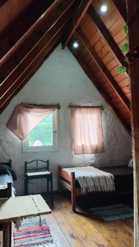 a attic room with a bed and a window at Chalet para 7 en Mar del Plata con parque y parrilla in Mar del Plata
