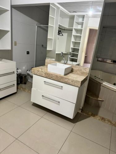 a bathroom with a sink and a mirror at Recanto do Galo in Volta Redonda