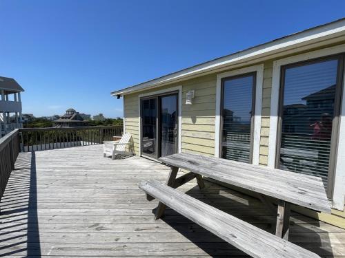 a wooden deck with a bench next to a house at SOUTHERN STAR cottage in Hatteras