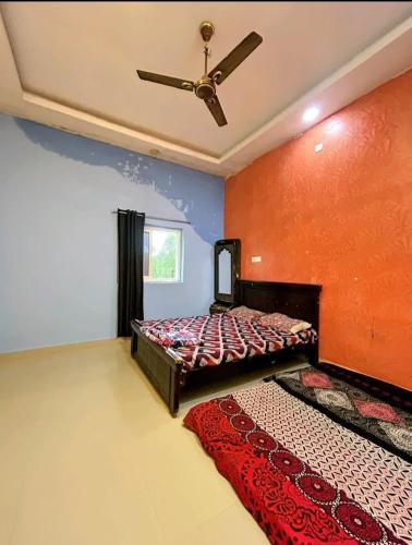 a bedroom with a bed and a ceiling fan at Mir's Farm House in Hyderabad