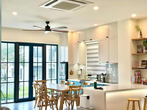 a kitchen with white cabinets and a table and chairs at Solara Coast Villa in Tiến Thành