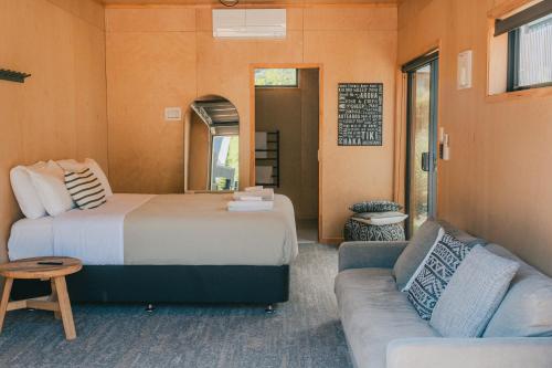 a room with two beds and a couch at Wavesong Oceans 11, Onetangi - Be My Guest Waiheke in Waiheke Island