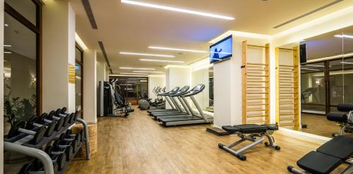 a gym with a row of treadmills and machines at Herbert Samuel Jerusalem in Jerusalem