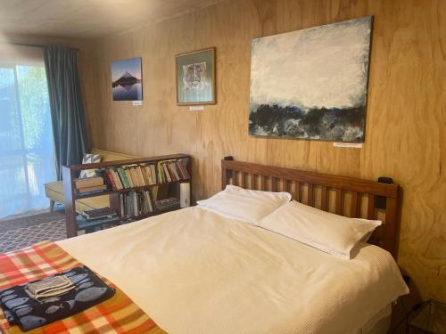 a bedroom with a bed and a book shelf at The Windsor Suite in New Plymouth
