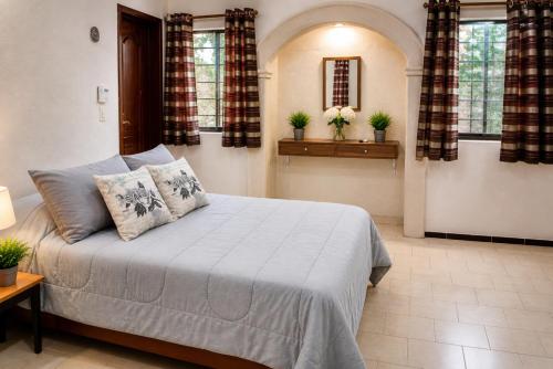 a bedroom with a large bed with two pillows at Villa Odalys Cozy Mexican style house in Mérida