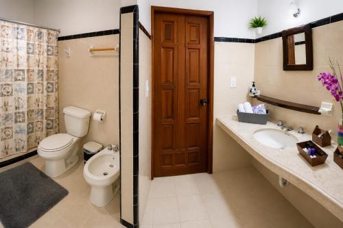 a bathroom with a toilet and a sink and a door at Villa Odalys Cozy Mexican style house in Mérida
