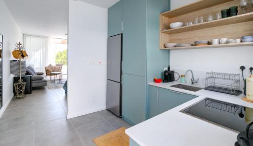 a kitchen with a sink and a refrigerator at Beachfront Bliss in Pissouri
