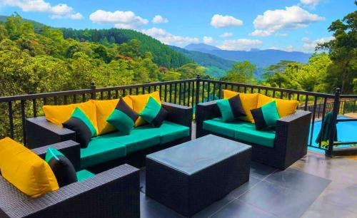 a balcony with couches and a pool and mountains at Grand Hills kandy in Kandy
