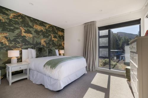 a bedroom with a large bed and a window at Vanda Heights in Queenstown